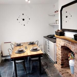 a kitchen with a wooden table and a fireplace at Make It Your Home in Wednesfield