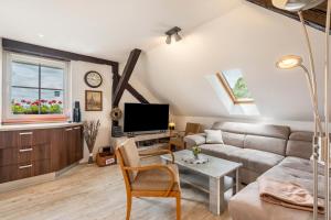 a living room with a couch and a tv at Ferienwohnung Zur alten Säge in Dresden