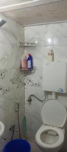 a bathroom with a white toilet and a sink at SAM PALACE DANDA Village in Mumbai