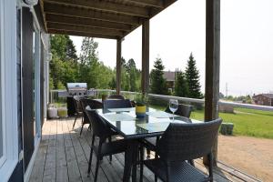 un patio con tavolo e sedie su un portico di Le Rassembleur, SPA & SALLE DE JEU a Petite-Rivière-Saint-François Altre 24 foto