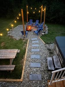 un cortile con focolare, sedie e luci di Le Rassembleur, SPA & SALLE DE JEU a Petite-Rivière-Saint-François