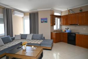a living room with a couch and a table at Amos Apartment in Sarandë +5 photos