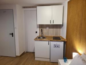 a small kitchen with white cabinets and a sink at Habitación con baño y cocina en Marín in Marín +4 photos