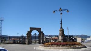 a statue in a plaza with a bridge in the background at Habitación con baño y cocina en Marín in Marín