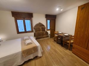 a bedroom with a bed and a table and a chair at Habitación con baño y cocina en Marín in Marín
