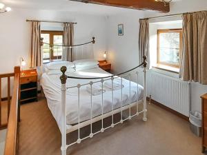 a bedroom with a white bed and a window at Hay Loft -23894 in Aylmerton
