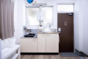 a bathroom with a sink and a machine in it at Osaka U-Shuku in Osaka