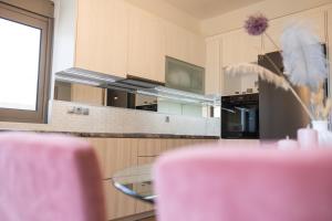 a kitchen with a table with pink chairs at Balance Suite in Kourouta