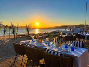 a table set up on the beach with the sunset at Croisette Beach Hotel Cannes - MGallery Collection in Cannes