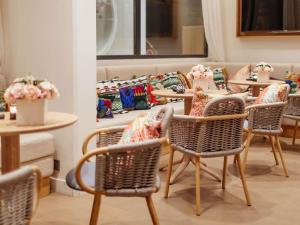 a group of tables and chairs with flowers on them at Croisette Beach Hotel Cannes - MGallery Collection in Cannes