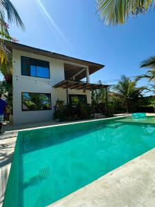 a house with a swimming pool in front of a house at Sand Beach Boutique Apartments in Bwejuu
