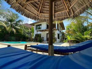 a villa with a swimming pool and a resort at Sand Beach Boutique Apartments in Bwejuu