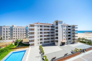 an apartment building with a swimming pool and the beach at Apartaments Lamoga - Monteixo in Torredembarra