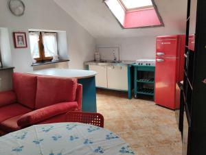 a kitchen with a red chair and a red refrigerator at Mansarda Giaveno in Giaveno