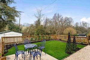 a table and chairs in a yard with a fence at Large Stylish House-2 Parking Spaces-Garden-Fire in Winchcombe