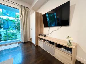 a living room with a flat screen tv on a wall at Relaxing Link to beach with pool in Hua Hin