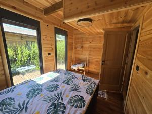 a bedroom with a bed in a wooden cabin at CabinAtRiver Ada Bojana in Ulcinj +5 photos