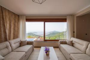 a living room with a couch and a large window at Villa Jana Lapčići in Lapčići