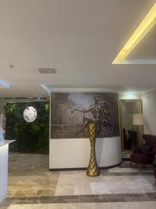 a statue in a room with a painting and a clock at Boris Hotel Beylikdüzü in Beylikduzu +65 photos