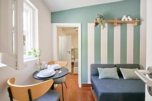 a living room with a blue couch and a table at Pateo do Tempo in Carcavelos
