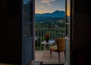Otwarte drzwi na balkon ze stołem i krzesłem w obiekcie BENVENUTI A CASA PAOLA , WELCOME IN GARFAGNANA! w mieście Castelnuovo di Garfagnana
