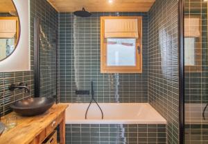 a bathroom with a tub and a sink at Chalet Le Rokh in Landry +28 photos