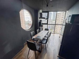 a dining room with a table and chairs and a window at Black Penthouse Naha 最大12名宿泊可 118平米 国際通り沿い 牧志駅 徒歩5分 in Naha +13 photos