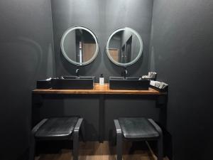 a bathroom with two sinks and two mirrors at Black Penthouse Naha 最大12名宿泊可 118平米 国際通り沿い 牧志駅 徒歩5分 in Naha