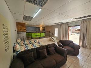 a living room with a couch and two chairs at Stay at 126 in Bloemfontein