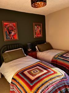 a bedroom with two beds with a colorful blanket at Little Hive in the Heartlands in Glastonbury