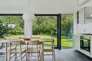 a kitchen with a table and chairs and a large window at Architect-Designed House By The Odder Coast in Odder +31 photos