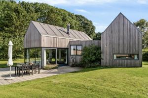 a timber house with a gambrel roof at Architect-Designed House By The Odder Coast in Odder