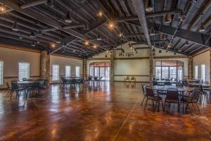 an empty ballroom with tables and chairs in it at AmericInn by Wyndham Pampa Event Center in Pampa