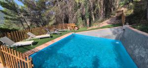 una piscina con due sedie a sdraio e una piscina di Cortijo Castillo de peñafleita a Siles