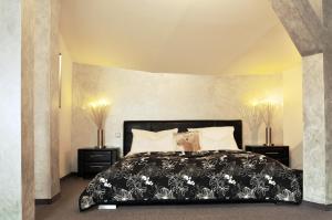 a bedroom with a black bed with white pillows at Park Ambiente Friedberg in Friedberg