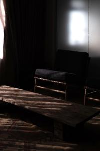 a dark room with a wooden table and two chairs at Hotel Anilevich Mansion in Beer Sheva