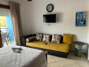 a living room with a couch and a clock on the wall at Cabo Dream a Cabo Negro in Cabo Negro