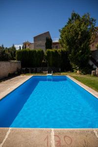 a large blue swimming pool in a yard at Hotel Casa Palacio Uclés in Uclés