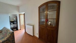 a living room with a large wooden china cabinet at La Casa in Piazza in Serre di Rapolano