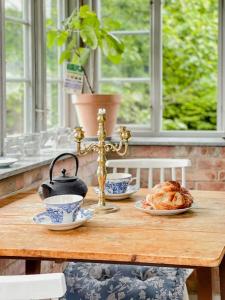 a table with a cross and plates of food on it at Timber-Framed House With Organic Farm In Nature in Stehag +28 photos