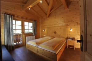 1 dormitorio con 1 cama en una habitación de madera en Hubers Chalet, en Mayrhofen