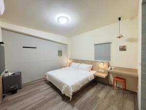 a bedroom with a white bed and a flat screen tv at 海洋星空民宿 in Magong