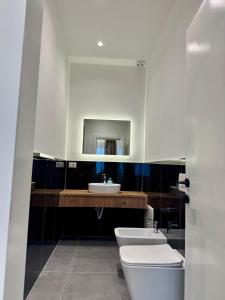 a bathroom with a sink and a toilet and a mirror at Apartamente Antoni Shengjin2 in Shëngjin +24 photos