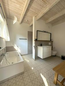 y baño grande con bañera y aseo. en Charming Forest House Near Lüneburg Heath, en Handeloh