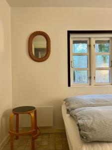 a bedroom with a mirror and a table next to a bed at Be Surrounded By Trees In A Thatched Cottage in Nykøbing Sjælland