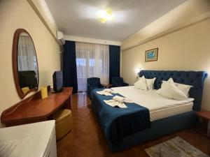 a hotel room with a bed and a desk at Hotel Vera in Eforie Nord