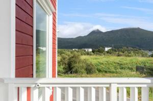 a window of a house with a white fence and mountains at Cozy Lofoten Hideaway in Leknes +34 photos