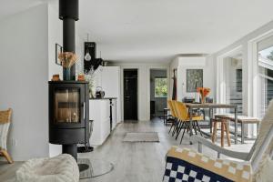 a living room with a stove and a table at Beautiful Tranquil Home By Fjord Near Copenhagen in Holbæk