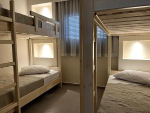 a bedroom with two bunk beds and a window at The 52 Spot in Kos Town