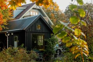 a black house with a black roof at Swedish Quarry Guesthouse in Lönsboda